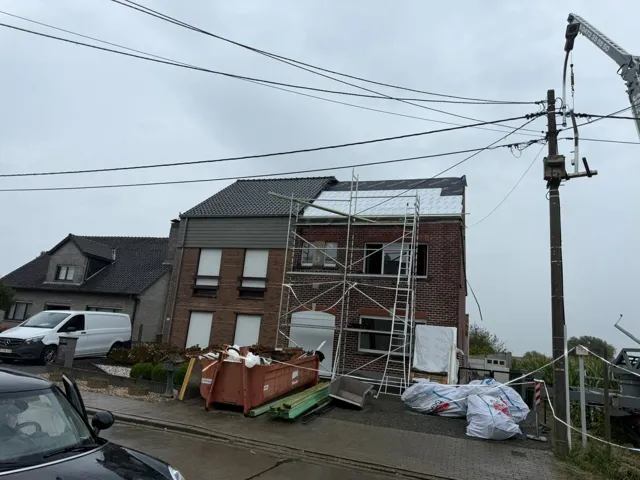 Rijwoning met stelling bij de start van dak- en gootwerken